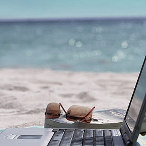 Picture of a digital nomad enjoying remote work in Cyprus with a laptop on a beach chair overlooking the ocean.Cyprus as a digital nomad destination. An image of a person working remotely with a laptop on a beach chair overlooking the Mediterranean Sea in Cyprus, showcasing the ideal work-life balance that can be achieved in this location.